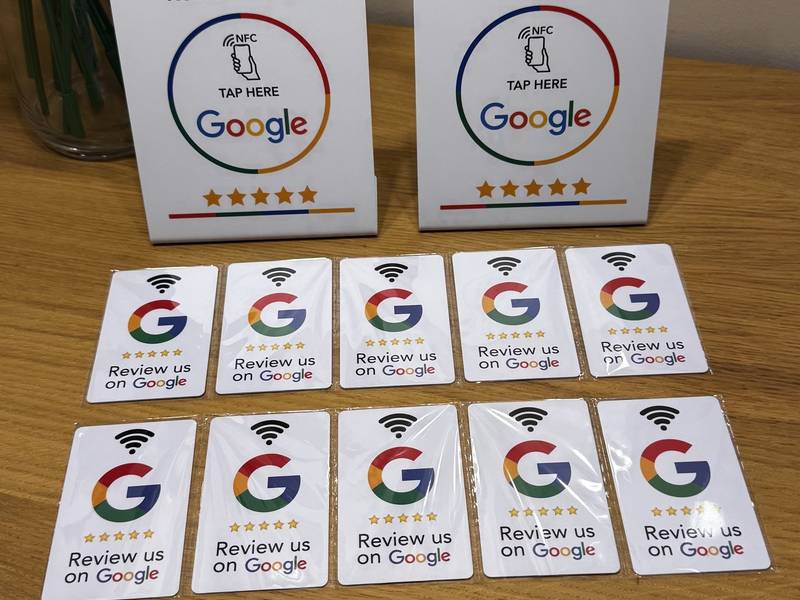 Két NFC-s Google-értékelő tábla és tíz értékelőkártya fa asztalon