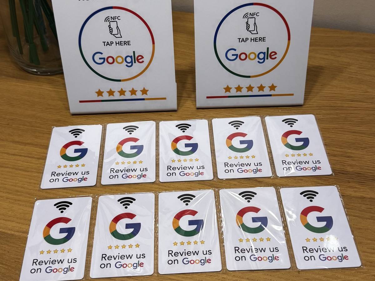Két NFC-s Google-értékelő tábla és tíz értékelőkártya fa asztalon