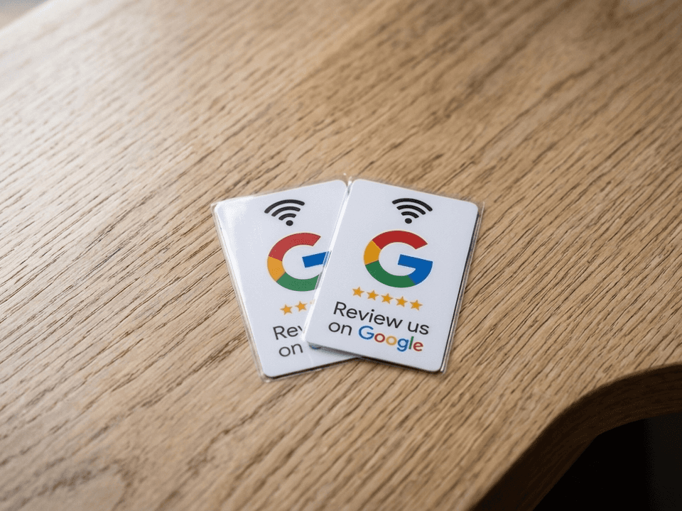 Két NFC-s Google-értékelő kártya fa asztalon