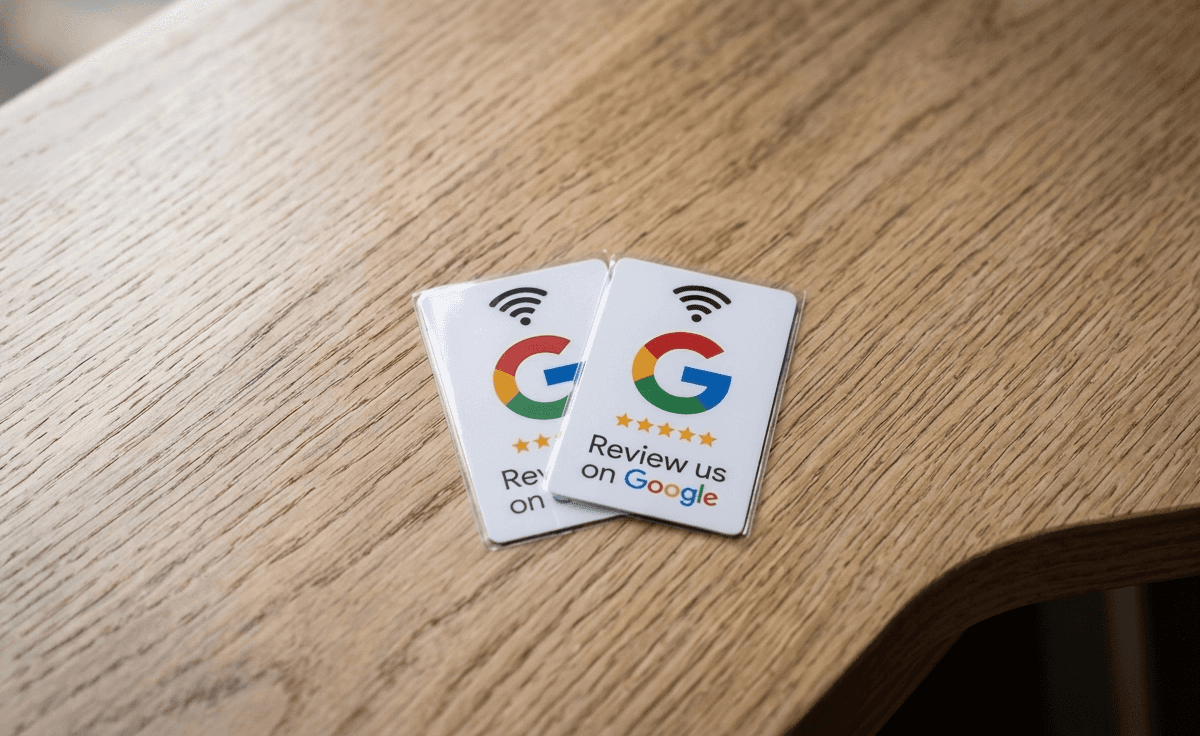 Két NFC-s Google-értékelő tábla és tíz értékelőkártya fa asztalon