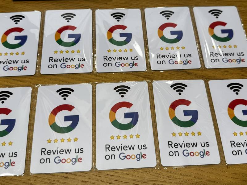 Fóliázott NFC-s Google-értékelő kártyák két sorban fa asztalon
