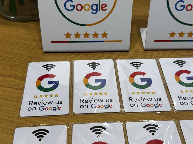 NFC-s Google-értékelő asztali tábla fa asztalon, előtte értékelőkártyák