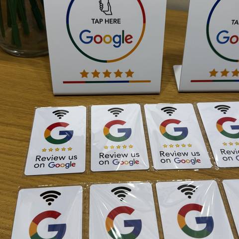 NFC-s Google-értékelő asztali tábla fa asztalon, előtte értékelőkártyák
